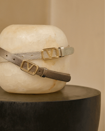 Twee Metallic riemen goud en brons om een witte stenenen statief